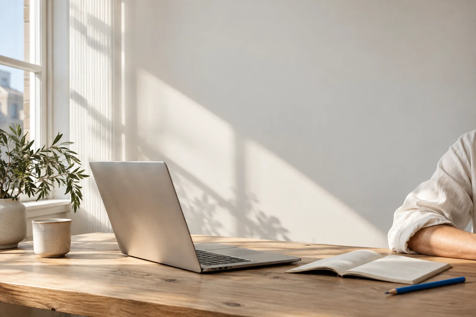 Daylight on a desk with a laptop and an open notebook